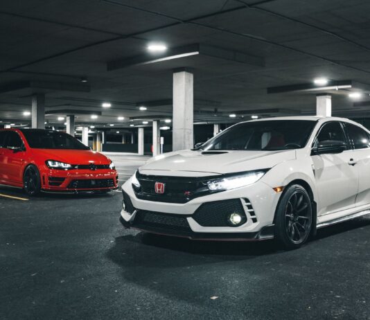 Czy warto kupić używane BMW M3 zamiast nowego hot hatcha? Białe i czerwone sportowe auta z włączonymi światłami w podziemnym garażu