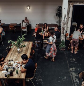 Zatłoczona restauracja, goście przy stolikach jedzą posiłki