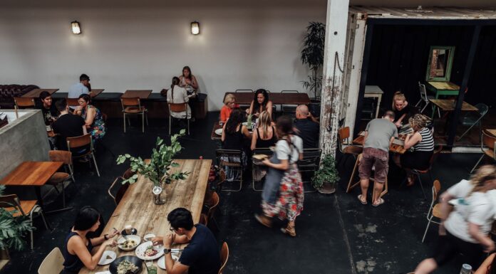 Zatłoczona restauracja, goście przy stolikach jedzą posiłki
